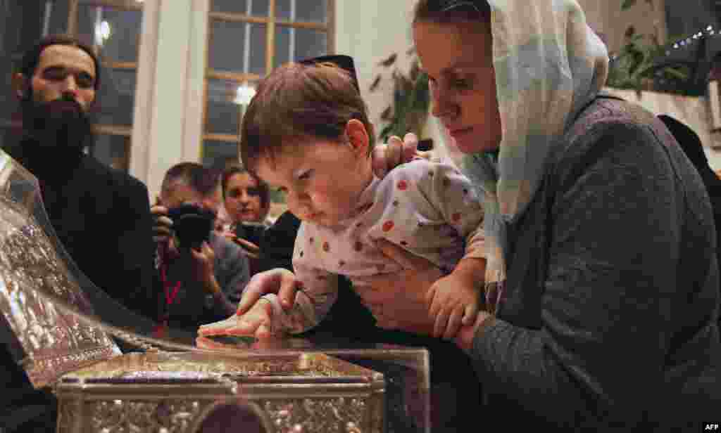 Tín đồ Chính Thống Giáo sờ bàn thờ bày thánh tích là Quà tặng của những Nhà Thông thái tại một nhà thờ ở Minsk, Belarus.