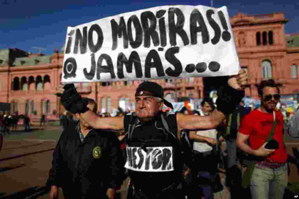 A man holds up a sign that reads in Spanish: "Nestor, you will never die", referring to late Argentina's President Nestor Kirchner, outside the government palace in Buenos Aires, Argentina, Wednesday, Oct. 27, 2010. Kirchner served as president from 2003