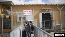 Des migrants africains marchant avec leurs bagages quittant le centre de rétention Holot, Israël le 25 Aout 2015 