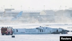 The wreckage of a Delta Air Lines-operated CRJ900 aircraft lays on the runway after a plane crash at Toronto Pearson International Airport in Mississauga, Ontario, Canada, Feb. 18, 2025. 