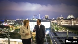 German Chancellor Angela Merkel and French President Francois Hollande speak after their joint news conference in the Chancellery in Berlin, May 15, 2012.