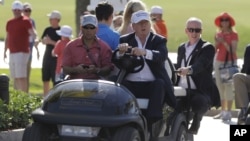 FILE - Donald Trump drives himself around a golf course in Doral, Florida.