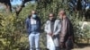 Journalists Samuel Takawira and Frank Chikowore stand with a police detective outside a court in Harare, Zimbabwe, May 23, 2020. (Columbus Mavhunga/VOA) 