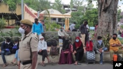 Warga mengenakan masker saat menungu kereta api di Hyderabad, India, 17 Juli 2020.