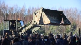A polish serviceman prepares to repair a barbed wire fence to stop migrants gathering at the Belarus-Poland border near Grodno Grodno, Belarus, Nov. 9, 2021. (Leonid Shcheglov/BelTA via AP)