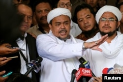 Leader of Islamic Defenders Front (FPI) Habib Rizieq (center) talks to reporters at a court after the blasphemy trial of Jakarta's incumbent governor Basuki Tjahaja Purnama, also known as Ahok, in Jakarta, Indonesia, Feb. 28, 2017.