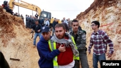 A plainclothes Israeli policeman (L) detains a Palestinian protester during a demonstration against Israel's construction of a road in the Arab neighborhood of Beit Safafa in Jerusalem, February 10, 2013.