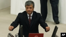 FILE - Mustafa Balbay, a Turkish journalist who was elected a lawmaker, takes his office oath at the parliament, Nov. 17, 2015, after spending nearly five years in jail, in Ankara, Turkey.