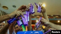 Members of Malaysian Muslim Wholesalers and Retailers Association (MAWAR), a non-governmental organization, throw Cadbury chocolate products into a dustbin as a protest and officially announced their boycott of Cadbury products, after their news conferenc