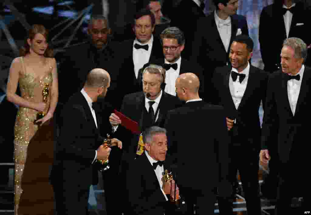 &quot;La La Land&quot; producer Jordan Horowitz (2L) speaks to stage manager Gary Natoli (C), reading the winners card, after &quot;La La Land&quot; mistakenly won the best picture instead of &quot;Moonlight&quot; at the 89th Oscars in Hollywood, California, Feb. 26, 2017.