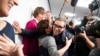 German Jens Soering, center, is embraced by a supporter after his arrival at the Frankfurt Airport in Frankfurt, Germany, Dec. 17, 2019. 