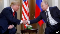 FILE - In this July 16, 2018 photo, U.S. President Donald Trump, left, and Russian President Vladimir Putin shake hands at the beginning of a meeting at the Presidential Palace in Helsinki, Finland.