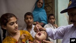 A Pakistani health worker gives a polio vaccine to a child in Rawalpindi, Pakistan, on May 6, 2014. 