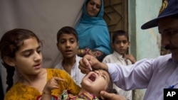 A Pakistani health worker gives a polio vaccine to a child in Rawalpindi, Pakistan, on May 6, 2014. 