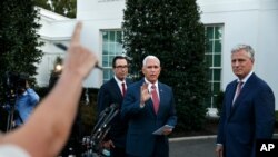 Vice President Mike Pence, center, with Treasury Secretary Steven Mnuchin, left, and White House national security adviser Robert O'Brien, waves as he turns to leave after speaking to reporters.