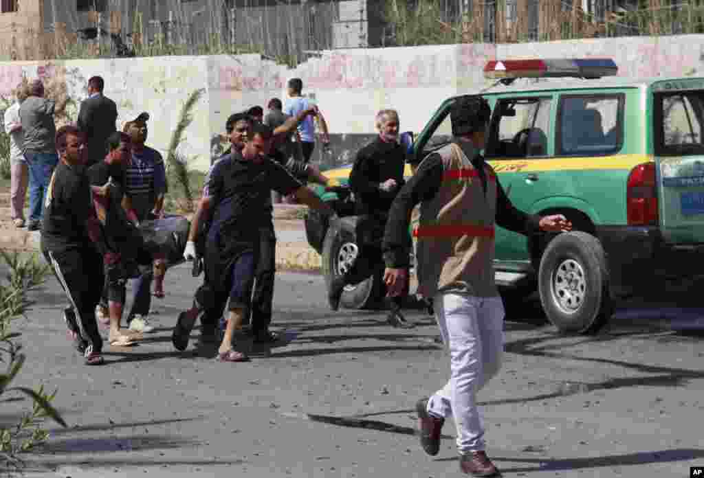 People carry the body of a car bomb victim following an attack near the municipal building in the Shi'ite stronghold of Sadr City, Baghdad, March 19, 2013.