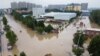 An aerial view shows rescue workers evacuating residents on a flooded road 