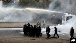 Polisi anti huru-hara menggunakan meriam air dan gas air mata untuk membubarkan para pengunjuk rasa di Champs-Elysees, Paris, 1 Desember 2018.