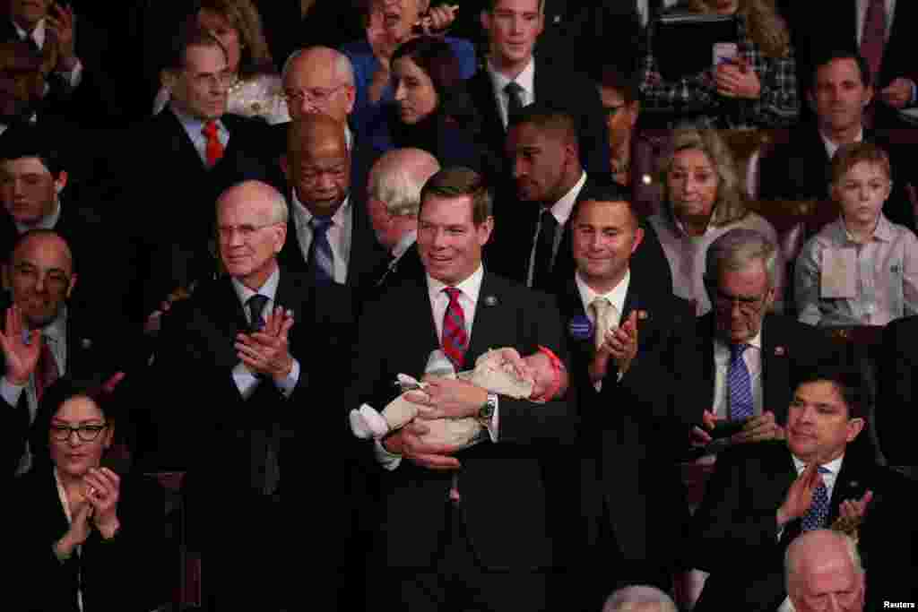 U.S. Rep. Eric Swalwell (D-CA) holds his daughter Kathryn as the U.S. House of Representatives meets for the start of the 116th Congress inside the House Chamber on Capitol Hill in Washington, Jan. 3, 2019. 