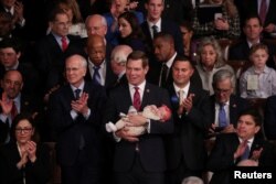 U.S. Rep. Eric Swalwell (D-CA) holds his daughter Kathryn as the U.S. House of Representatives meets for the start of the 116th Congress inside the House Chamber on Capitol Hill in Washington, Jan. 3, 2019.