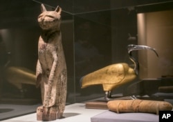 In this March 20, 2014 photo, a cat coffin with mummy, left, and an ibis coffin is displayed as part of the exhibit at the Orange County's Bowers Museum in Santa Ana, CA. (AP Photo/Damian Dovarganes)