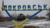 FILE - A military vehicle passes by a road sign that reads 'Pokrovsk’ near a front line in the Donetsk region.