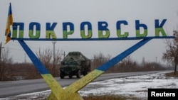 FILE: Sebuah kendaraan militer melewati rambu jalan bertuliskan 'Pokrovsk', di tengah serangan Rusia terhadap Ukraina, di kota Pokrovsk, dekat garis depan di wilayah Donetsk, Ukraina, 19 Desember 2024. (Alina Smutko/REUTERS)