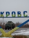 FILE - A military vehicle passes by a road sign that reads 'Pokrovsk’ near a front line in the Donetsk region.