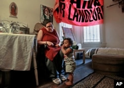 FILE - Franki Velez looks at her son Ashoka Little, 1, in their home in Oakland, California, Feb. 17, 2017. An Iraq War veteran who says she is on disability for Post Traumatic Stress Disorder, Velez is a full-time activist who is simultaneously cheered by and worried about the post-Trump infusion of more traditional liberals eager to protest.