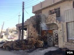 Neighbors say this small shop was occupied by IS militants and hit by an airstrike in January. They say the blood on the wall belongs to a family fleeing in the struck car on Feb. 7, 2017, in Mosul, Iraq. (H. Murdock/VOA)