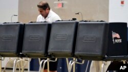 A voter looks over a ballot during New Mexico's primary elections at La Cueva High School in Albuquerque, New Mexico, June 5, 2018. (AP Photo/Russell Contreras)