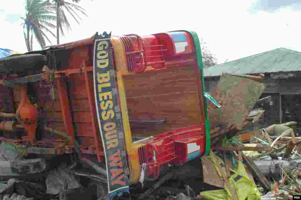 The storm surge toppled vehicles, most of which are yet to be moved, Tacloban, Nov. 21, 2013. (Steve Herman/VOA)