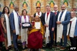 This handout photograph taken and released on June 19, 2024 by the Official website of Dalai Lama shows a group of senior US lawmakers including former House speaker Nancy Pelosi (3L) poses with Tibetan spiritual leader Dalai Lama (C) for photos after a m
