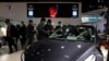 Visitors look at a Tesla Model 3 during the Shanghai Auto Show in Shanghai, April 21, 2021.