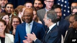 FILE - Ambassador-at-Large John Nkengasong, new head of the Bureau of Global Health Security and Diplomacy at the State Department, center left, is applauded by Secretary of State Antony Blinken Tuesday, Aug. 1, 2023, at the State Department in Washington. 