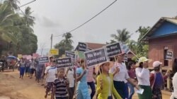 Children hold signs during an anti-coup procession from Nyinmaw to Tizit, Myanmar, March 17, 2021 in this still image obtained from social media video. (Dawei Watch via Reuters)