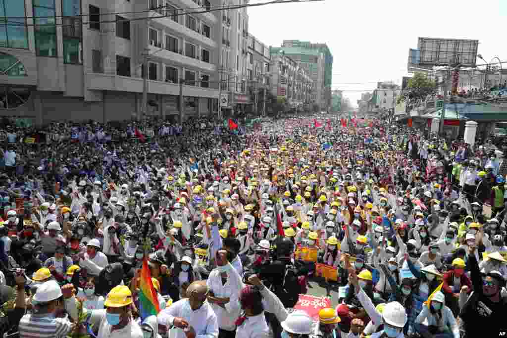 Anti-coup protesters raise their hands with clenched fists during a nationwide general strike near the Mandalay Railway Station in Mandalay, Myanmar.
