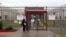 This April 13, 2009 photo shows an employee of Immigration and Customs Enforcement's Stewart Detention Center in Lumpkin, Georgia., waiting for the front gate to be opened. 