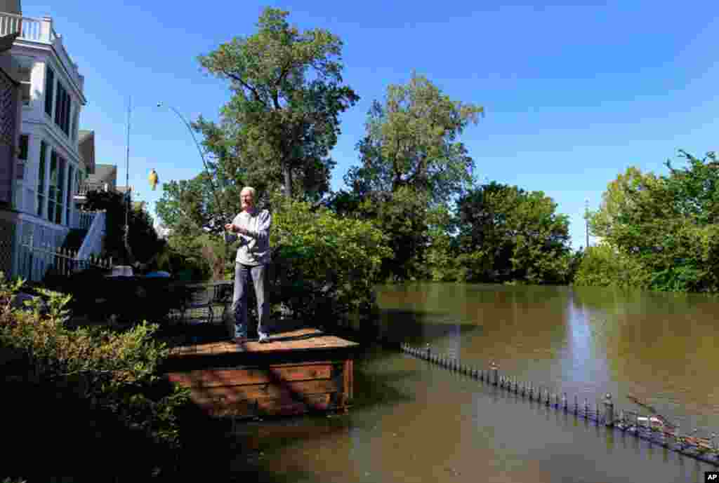 Cyril Forck, age 90, catches a small perch from his backyard deck, which is usually 50 feet away from the edge of the Mississippi River, on Mud Island in Memphis, Tenn. (AP Photo/Lance Murphey)