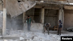 Residents remove debris after an airstrike on the rebel held al-Maysar neighborhood in Aleppo, Syria, April 11, 2016.