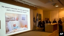 Israeli Prime Minister Benjamin Netanyahu, second left, watches the screen during a press conference at the Foreign Ministry in Jerusalem, Oct. 15, 2015.