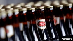 FILE - Bottles of beer move along a production line at a factory of Saigon Beer Corporation (Sabeco) in Hanoi, Vietnam, May 26, 2015. A stake in the company is for sale Monday.