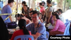 FILE PHOTO - Tan Song, a doctor, and president of the Cambodian Health Professionals Association of America (CHPAA) examines a patient during a medical mission in Cambodia's Svay Rieng province, Cambodia. 
