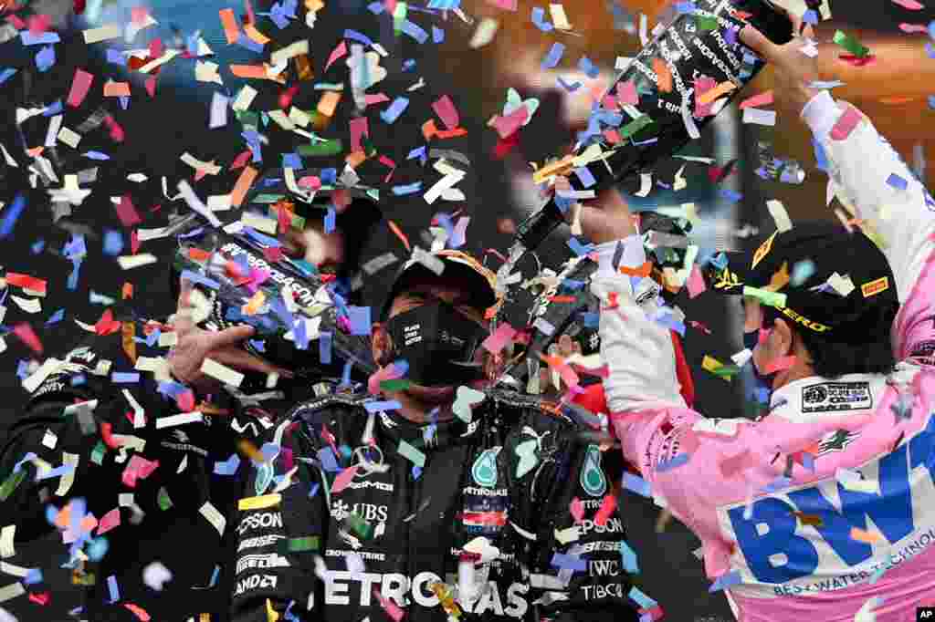 Second placed Racing Point driver Sergio Perez of Mexico, right, pours champagne on winner Mercedes driver Lewis Hamilton of Britain on the podium of the Formula One Turkish Grand Prix at the Istanbul Park circuit racetrack in Istanbul, Turkey.