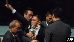 Pro-democracy lawmaker Wu Chi-wai, center, is escorted by security from the chamber after protesting as Hong Kong Chief Executive Carrie Lam holds a question and answer session at the Legislative Council in Hong Kong, Oct. 17, 2019.