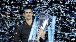 Novak Djokovic memegang tropi ATP World Tour setelah menang dalam tunggal putra turnamen itu di London, 12/11/2012. ATP akan menaikkan hadiah uang untuk Turnamen World Tour 500.