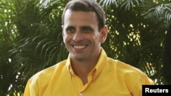 Opposition candidate Henrique Capriles shows his certification after the registration of his presidential bid in Caracas June 10, 2012.