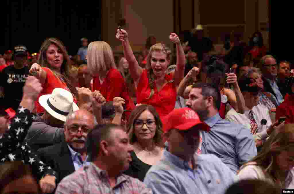 Attendees dance to the music as they wait for U.S. President Donald Trump to take the stage during a campaign event at the Arizona Grand Resort and Spa in Phoenix, Sept. 14, 2020.