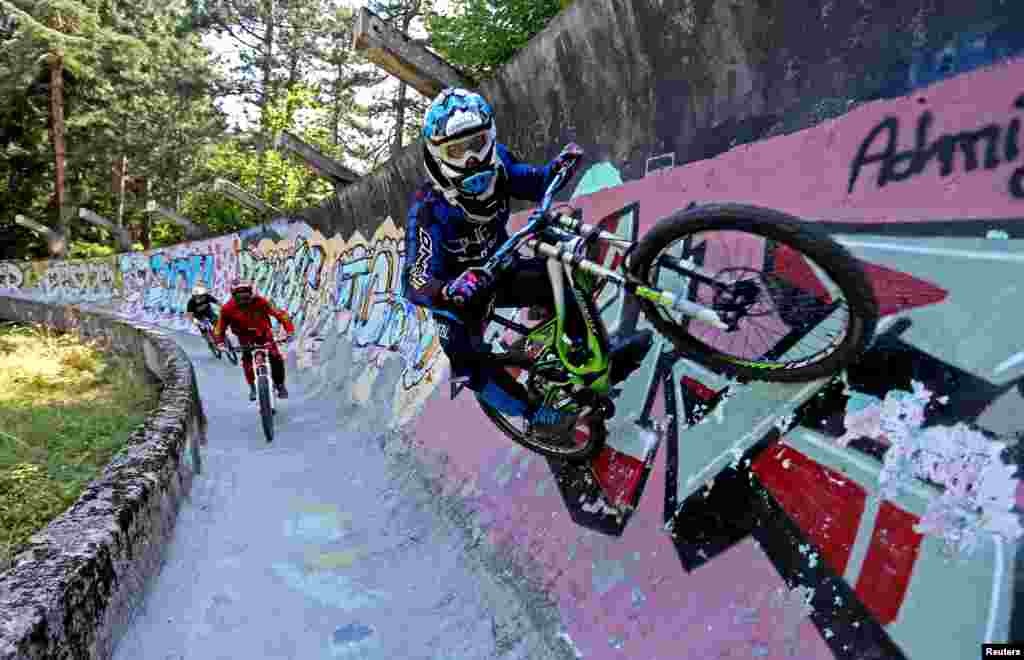 Downhill bikers Kemal Mulic (C), Tarik Hadzic (L) and Kamer Kolar train on the disused bobsled track from the 1984 Sarajevo Winter Olympics on Trebevic mountain near Sarajevo, Bosnia and Herzegovina, Aug. 8, 2015. Abandoned and left to crumble into oblivion, most of the 1984 Winter Olympic venues have been reduced to rubble by neglect as much as the 1990s conflict that tore apart the former Yugoslavia.
