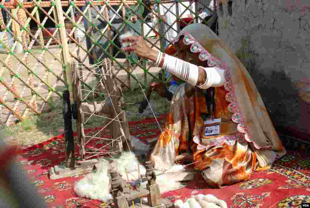 وادی مہران سے تعلق رکھنے والی خاتون روایتی چرخے پر سوت کات رہی ہے۔